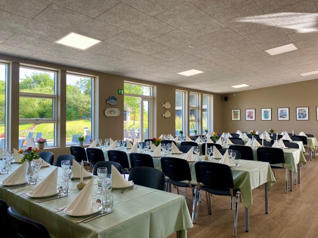 Dette er taget inde i Søpavillonen og viser nogle borde, der er dækket op til fest. Ud af vinduerne kan anes terassen samt udsigten over til en lille rislende bæk, der løber ud i Storesø, som ligger ved Storkesøen i Ribe.